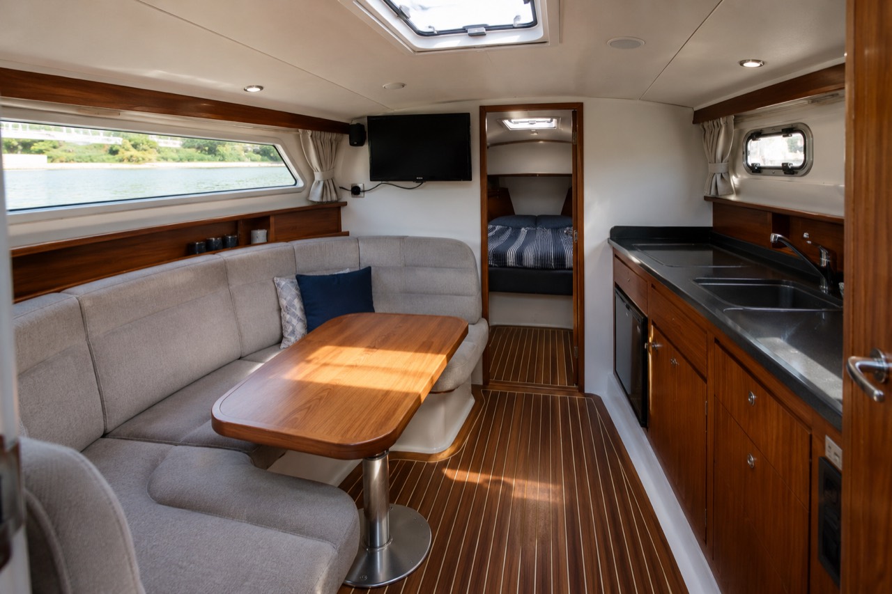 Heller Innenraum einer Yacht mit Kabine, Sitzbereich und Pantry